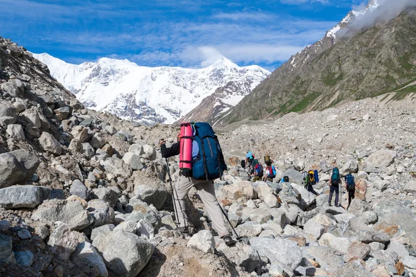 Hikier is jumping on rocks in Caucasus mountains in Bezengi regi — Stock Photo, Image