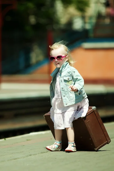 Imagen de aspecto vintage de una niña pequeña con equipaje en el railwa —  Fotos de Stock