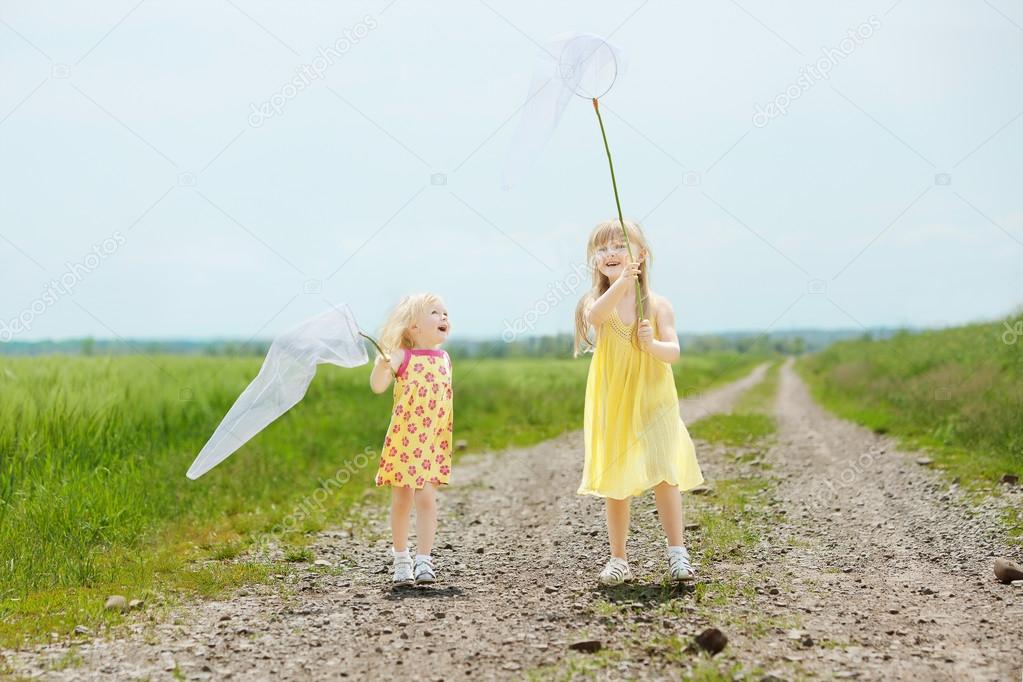 Girls with butterfly net having fun at field