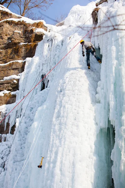 Homem escalando cascata congelada — Fotografia de Stock