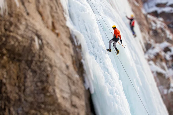 Hombre escalando cascada congelada — Foto de Stock