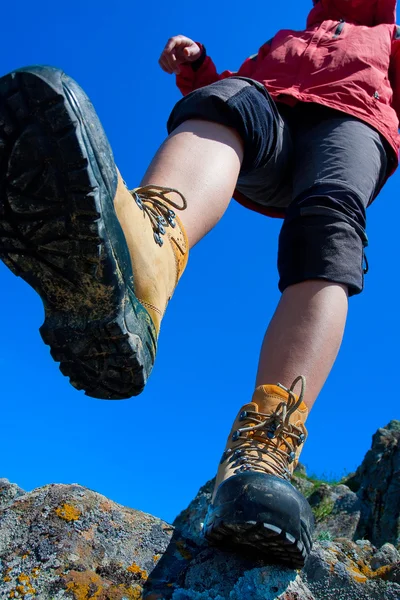 Bota de senderismo primer plano en rocas de montaña — Foto de Stock