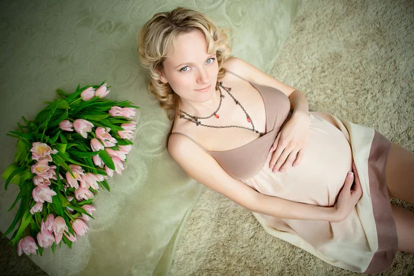 Krásná těhotná žena doma podívat na kameru — Stock fotografie