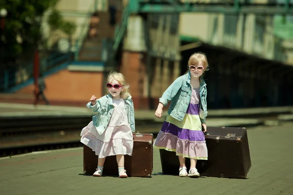 Imagen de aspecto vintage de las niñas pequeñas con el equipaje en el ferrocarril —  Fotos de Stock