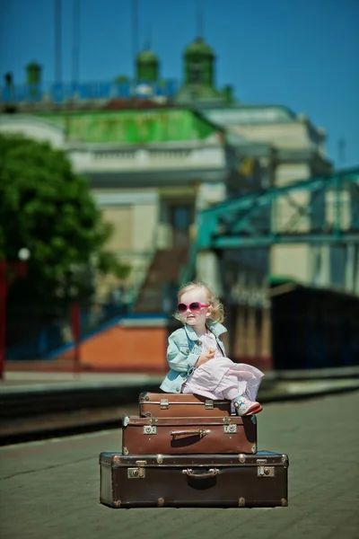 Vintage looking picture of small girl with luggage at the railwa — Stock Photo, Image