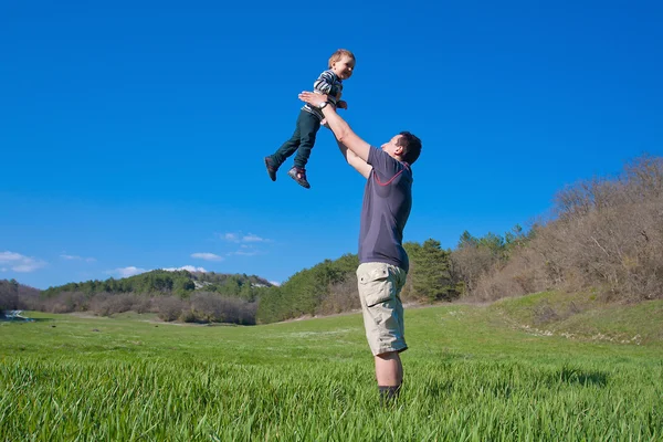 Far är att leka med sonen 1,5 år på ängen — Stockfoto