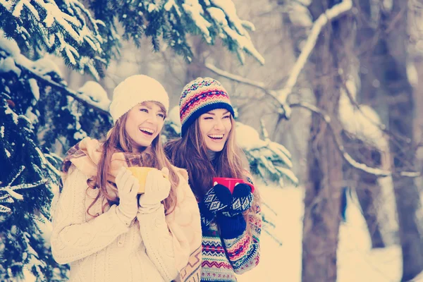Duas jovens mulheres com copos coloridos bebendo chá ao ar livre e smil — Fotografia de Stock