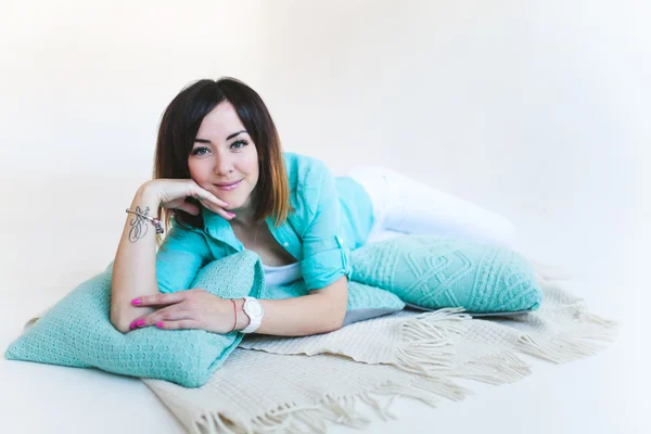 Menina com almofadas camisa turquesa — Fotografia de Stock