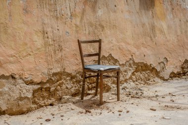 Duvara yaslanmış eski bir sandalye.