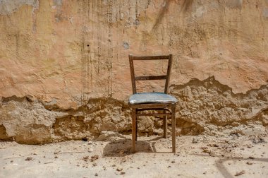 Duvara yaslanmış eski bir sandalye.