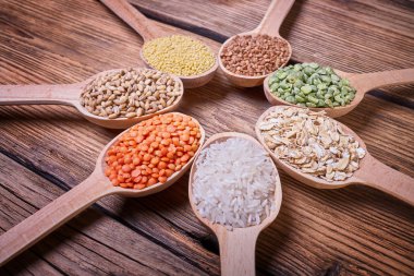 Tahta kaşıklar içinde tahıl çeşitleri