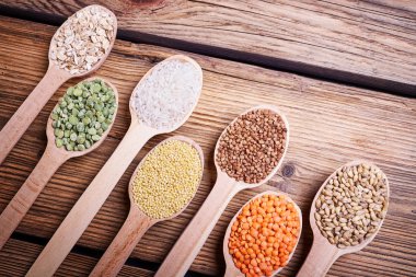 Tahta kaşıklar içinde tahıl çeşitleri