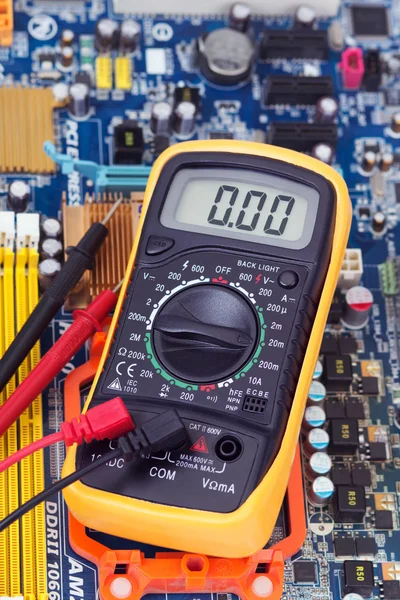 Multimeter and motherboard — Stock Photo, Image