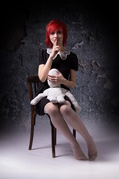 神秘的な赤い髪の少女と人形の椅子の上 — ストック写真