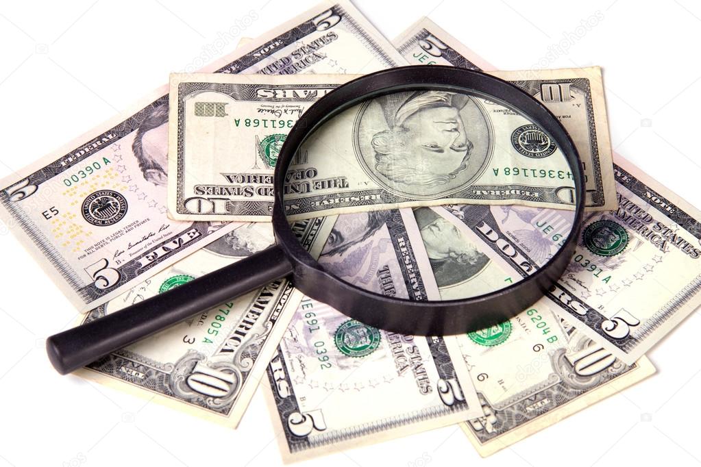 Dollars and magnifying glass on a white background