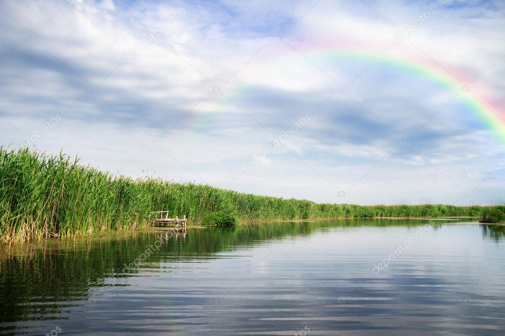 Rainbow after storm on the river landscape
