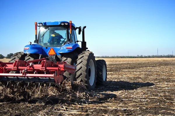 Farmer on a tractor plowed field — Stock Photo, Image
