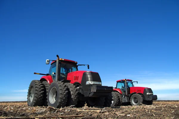 Dois tratores cultivando a terra — Fotografia de Stock