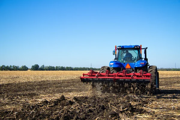 트랙터가 농장에서 땅을 경작하는 모습 — 스톡 사진