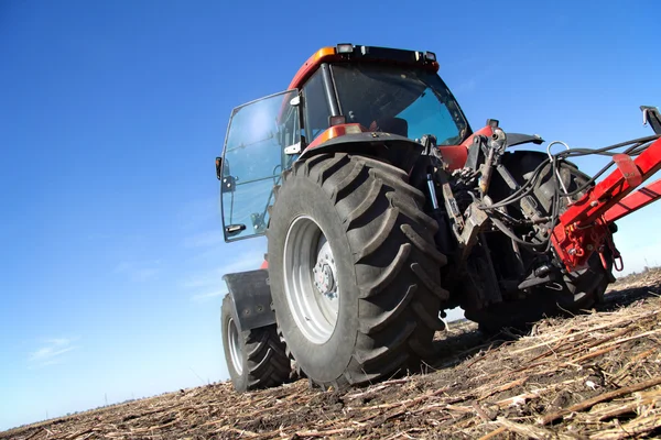 Röd traktor med plog — Stockfoto