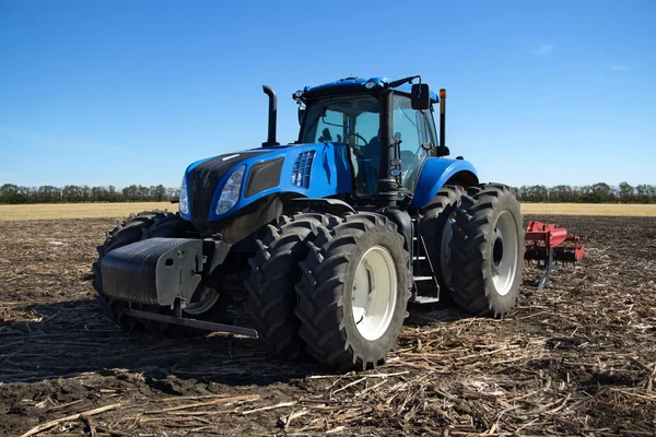 Blå traktor med plog — Stockfoto