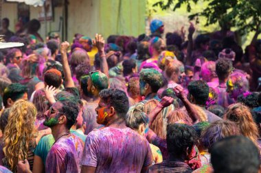 10.03.2020 Hampi. Hindistan. Kilit altına alınmadan ve covid 19 salgını başlamadan önce bir sürü insan birbirine renk boyası fırlatıyor. Aşk festivali, iyinin kötülüğe karşı zaferi ve baharın gelişi.