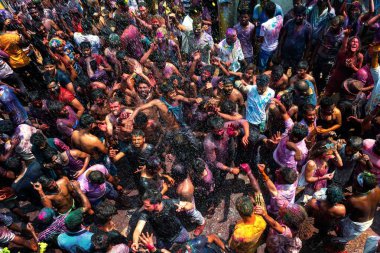 10.03.2020 Hampi. Hindistan. Kilit altına alınmadan ve covid 19 salgını başlamadan önce bir sürü insan birbirine renk boyası fırlatıyor. Aşk festivali, iyinin kötülüğe karşı zaferi ve baharın gelişi.