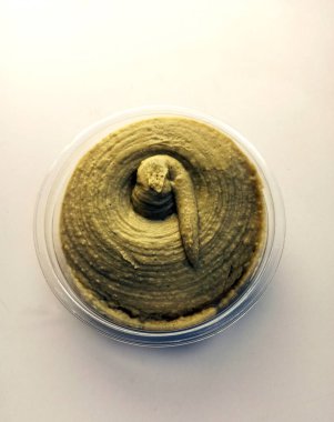 Avokado humusu, sebzeli beyaz arka planla çevrili.