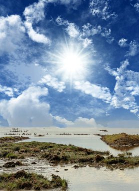 Gün batımında bir gölle Afrika manzarası.