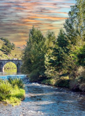 Fransa 'nın güneyinde, gün batımında nehirde köprü.