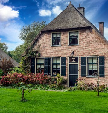 Giethoorn, bulutlu bir günde kanalları ve kırsal evleri olan Hollanda köyü.