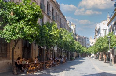 SEVILLA, İSPAN - Temmuz 2021. Güneşli bir günde İspanya 'nın güneyinde Sevilla caddesinde yürüyen bir turist..