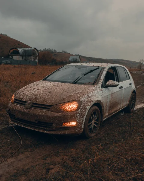 Beyaz araba çamura saplandı ve doğada çok kirlendi.