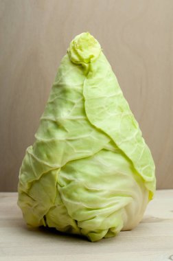 Öküz kalbi ya da sivri uçlu lahana kafası tahta bir masanın üzerinde dikiliyor.