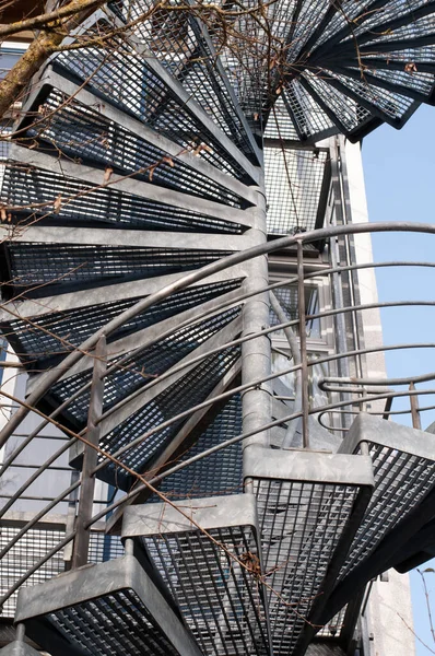 a spiral metal staircase as emergency exit at a building in a city