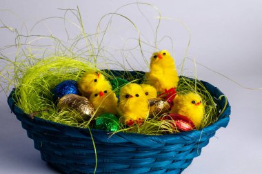 Küçük ahşap bir sepet, tekstil tavuğu ve çikolatalı yumurta.