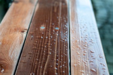 water drops on the lacquered planks of a garden bench after rain clipart