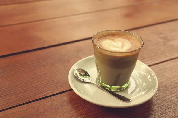 Coffee latte art on the wood texture background - Vintage effect — Stock Photo, Image