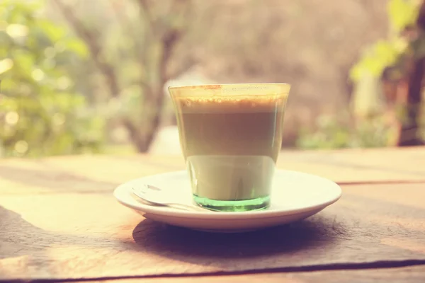 Kaffe latte art på trä textur bakgrunden - Vintage effekt — Stockfoto