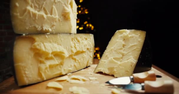 Parmesão de cabeça de queijo duro médio em tábua de madeira, com facas de queijo parmesão. Tiro deslizante. — Vídeo de Stock