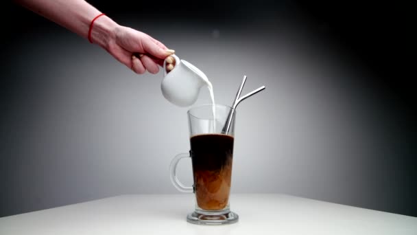 Hand hält Melker und gießt Milch in einen Kaffeebecher. — Stockvideo