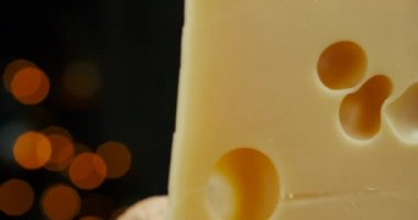 Orta boy sert peynirli Edam gouda parmesan peynirinin bir kısmını ahşap tahtada, fındık ve üzümler tabakta dönüyor..