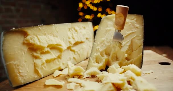 Parmesão de cabeça de queijo duro médio em tábua de madeira, com facas de queijo parmesão. Tiro deslizante. — Vídeo de Stock