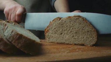 Mutfakta ekmek kesen bir kadın. Sandviç yapmak için ekmek dilimliyorum. Yemek pişirme süreci