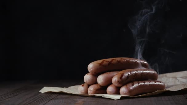 Primer plano de salchichas a la parrilla sobre una mesa de madera. — Vídeo de stock