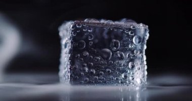 Kapalı arkaplanda dönen buz küpleri.