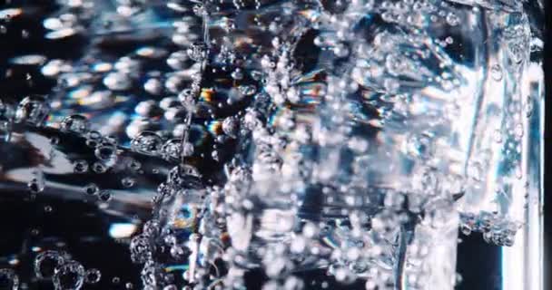 La soda y el hielo en el vaso tienen burbujas. Primer plano de vídeo. — Vídeo de stock