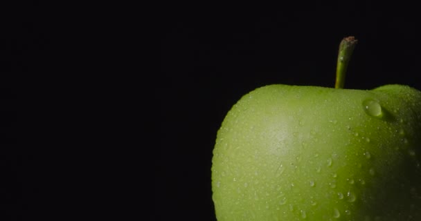 Yeşil ıslak elma, koyu bir arka planda asılı duruyor, izole.. — Stok video