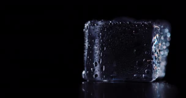 Крупним планом кубики льоду, що обертаються на темному фоні . — стокове відео