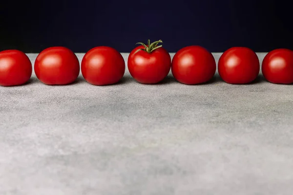 Koyu arkaplanda kırmızı domates çizgisi. Organik sağlıklı yiyecekler. Çiğ domates. Taze sebze.